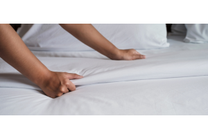 Housekeeper changing hotel bed