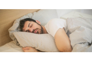 Man sleeping with striped duvet cover