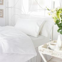White 144 thread count 50/50 polycotton duvet cover on bed with pillows in white bedroom.