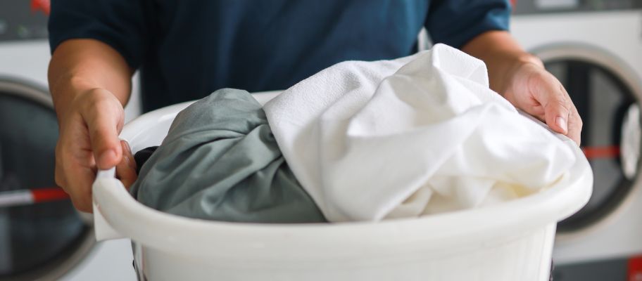 Man carrying laundry basket full of dirty laundry